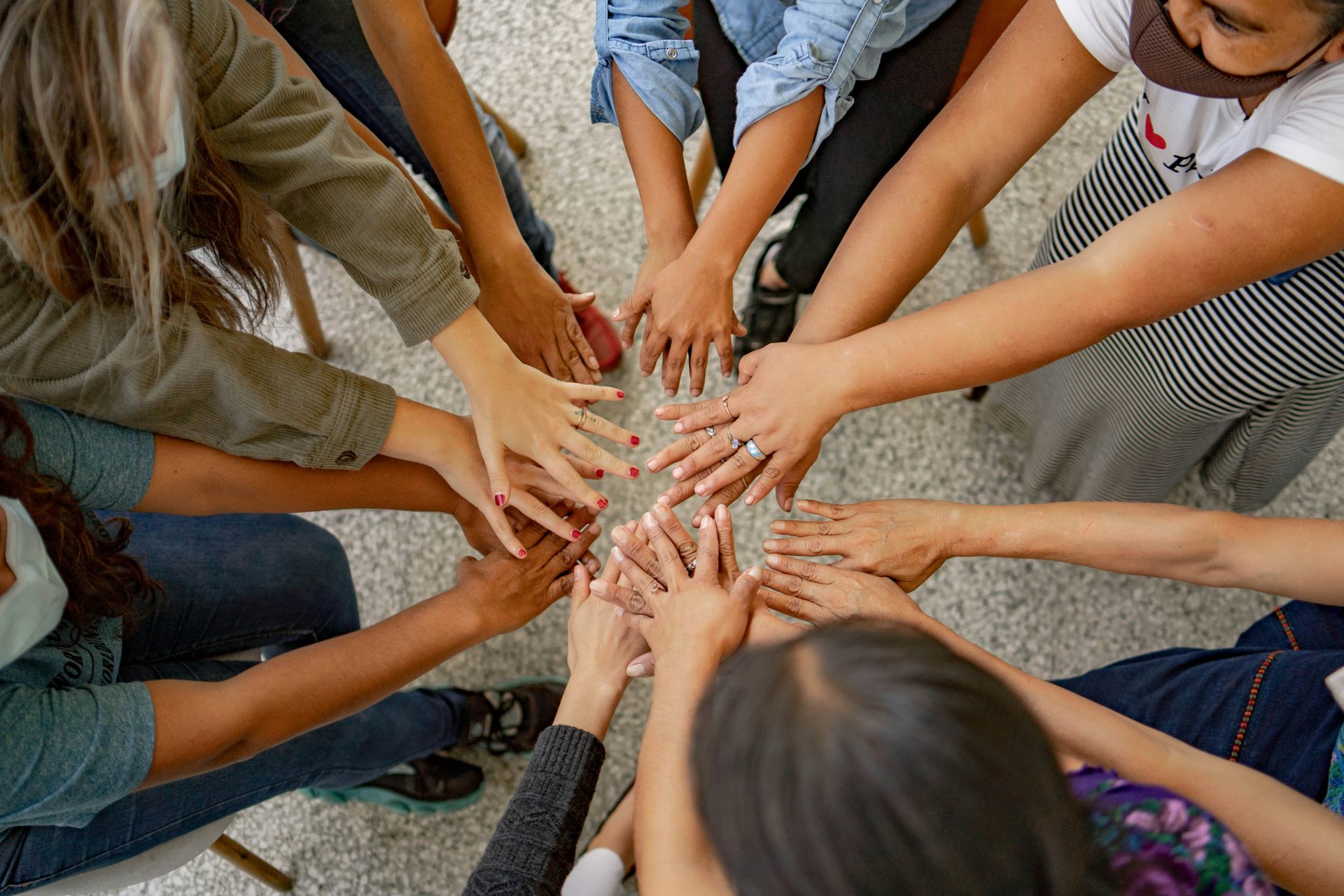 Un groupe de personnes debout en cercle, les mains jointes